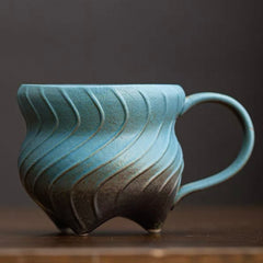 Three-legged ceramic cup