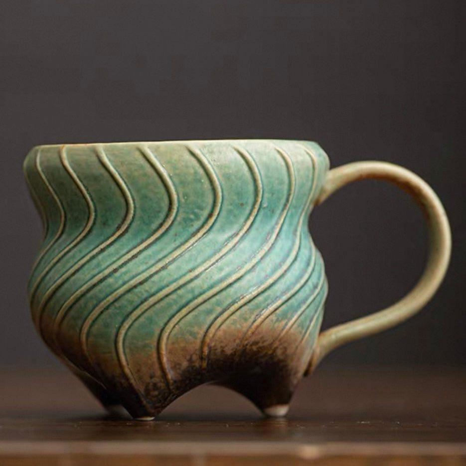 Three-legged ceramic cup