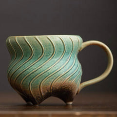 Three-legged ceramic cup